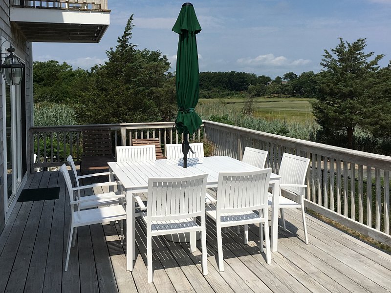 Left View Image Of Dining Table With Chairs On A Terrace In Our 3 Boardwalk Cape Cod Vacation Rental